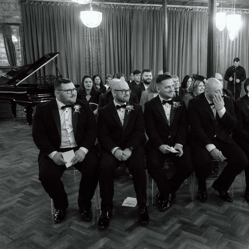 groomsmen in black tuxedos ceremony