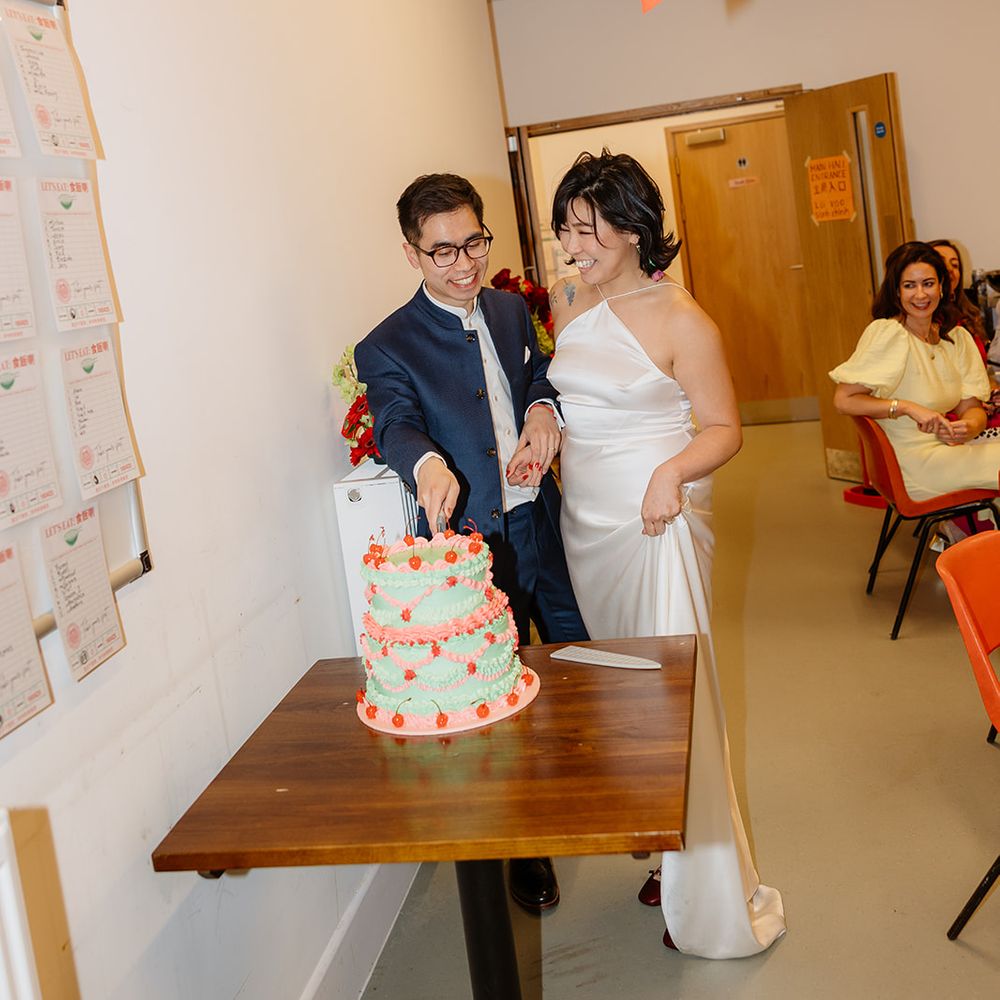 bride and groom cut pink and green cake