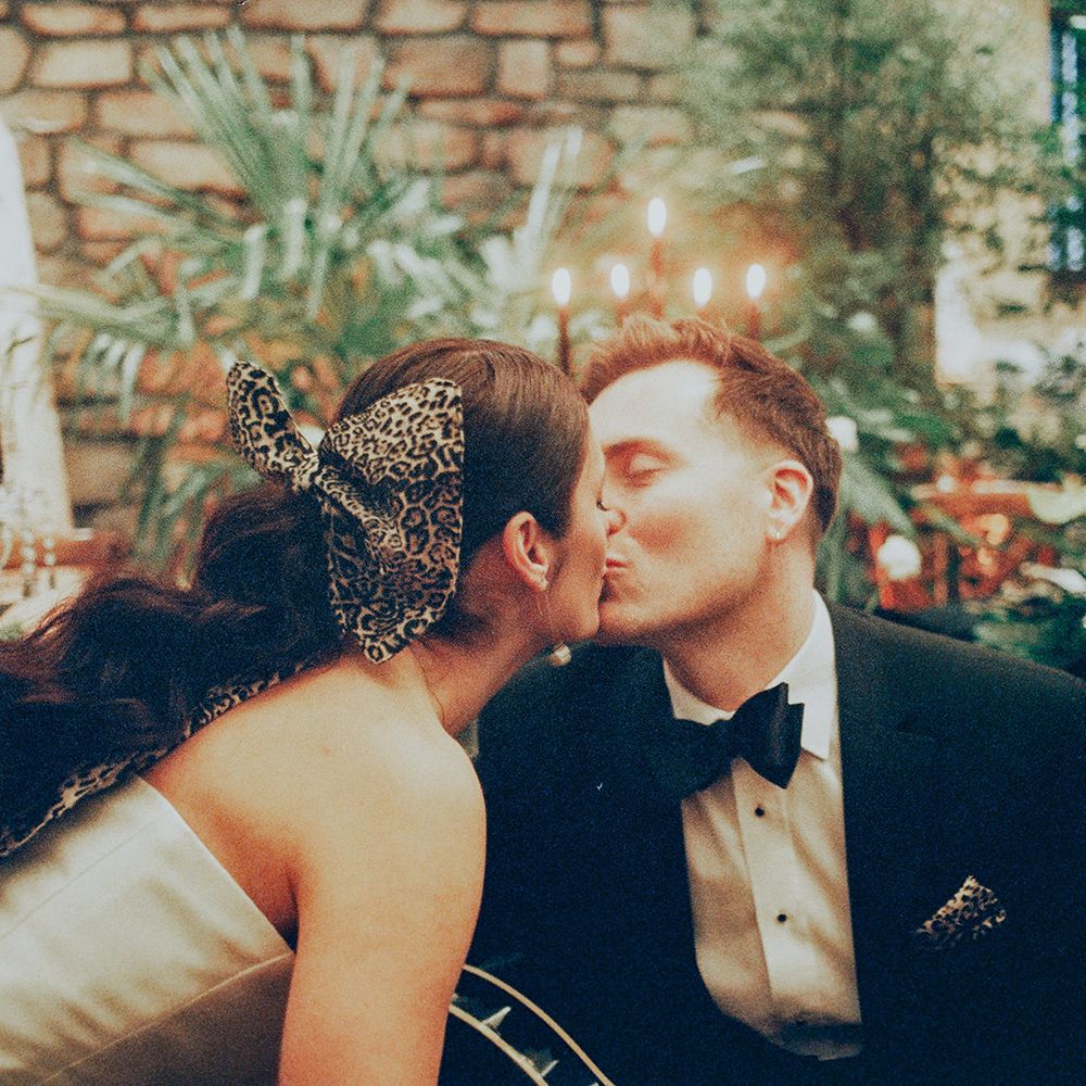 couple share kiss with leopard hair bow