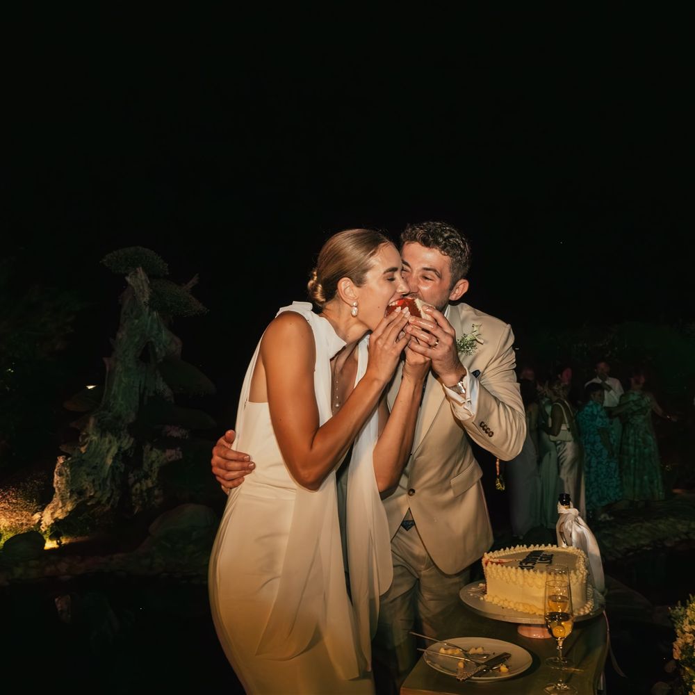 couple try first bite of wedding cake
