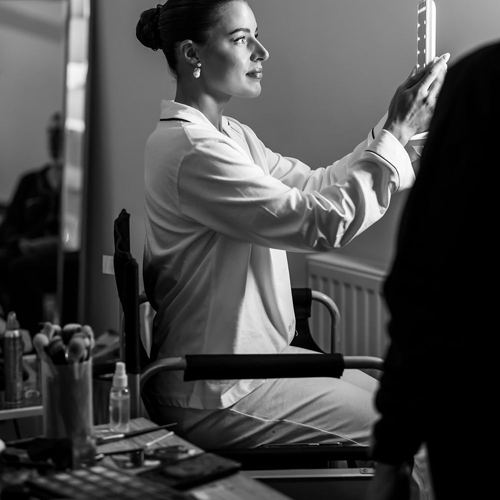 bride getting ready in silk pyjamas and pearl earrings