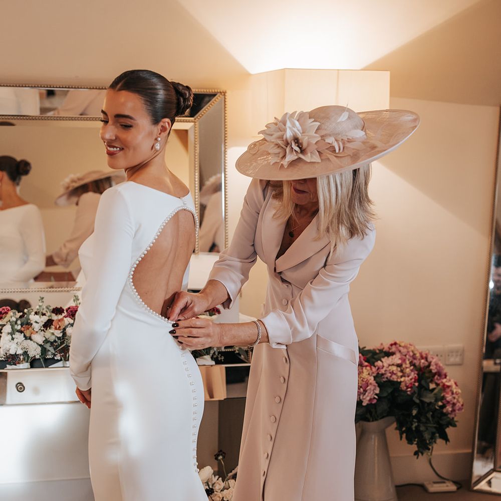bride and mother of bride getting ready in long sleeve wedding dress