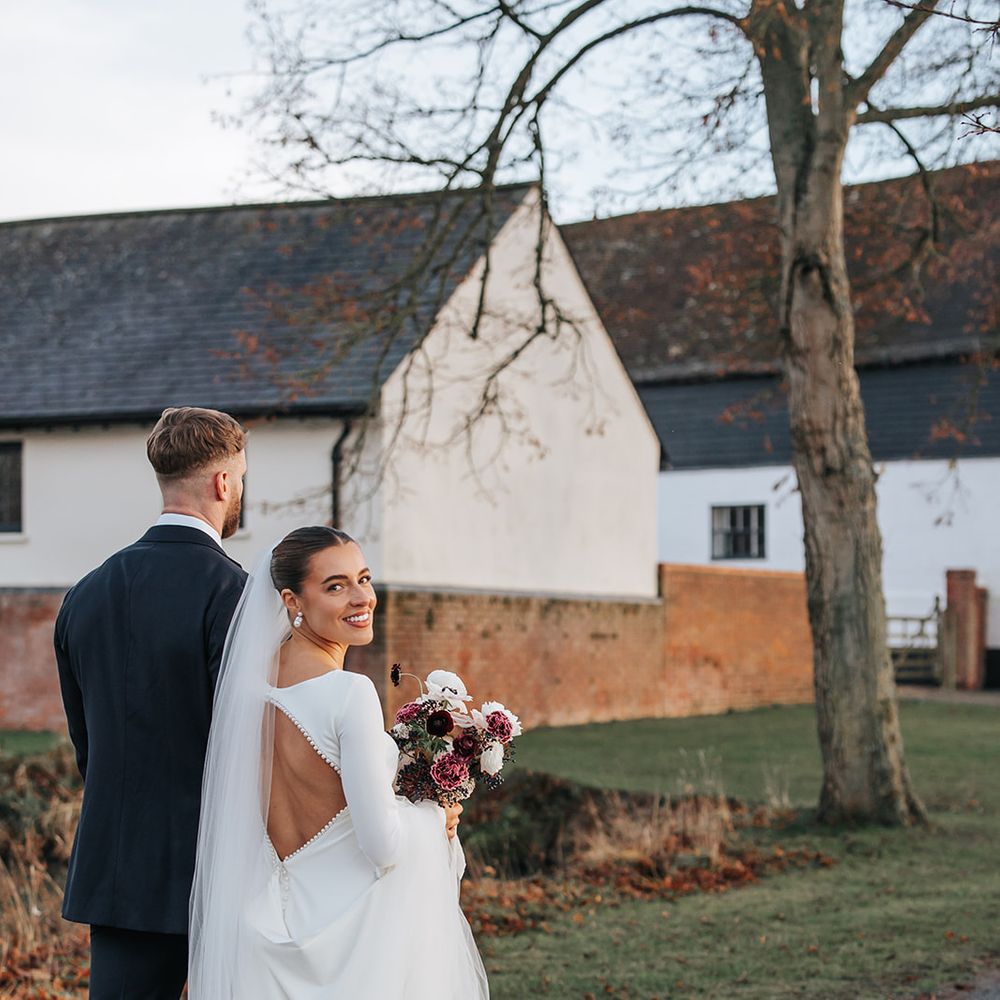 bride with open back long sleeve wedding dress winter