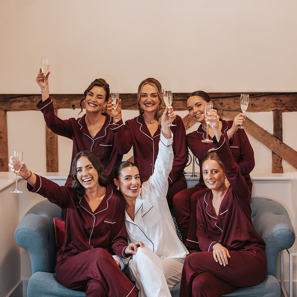 bridesmaids getting ready in matching burgundy pyjamas