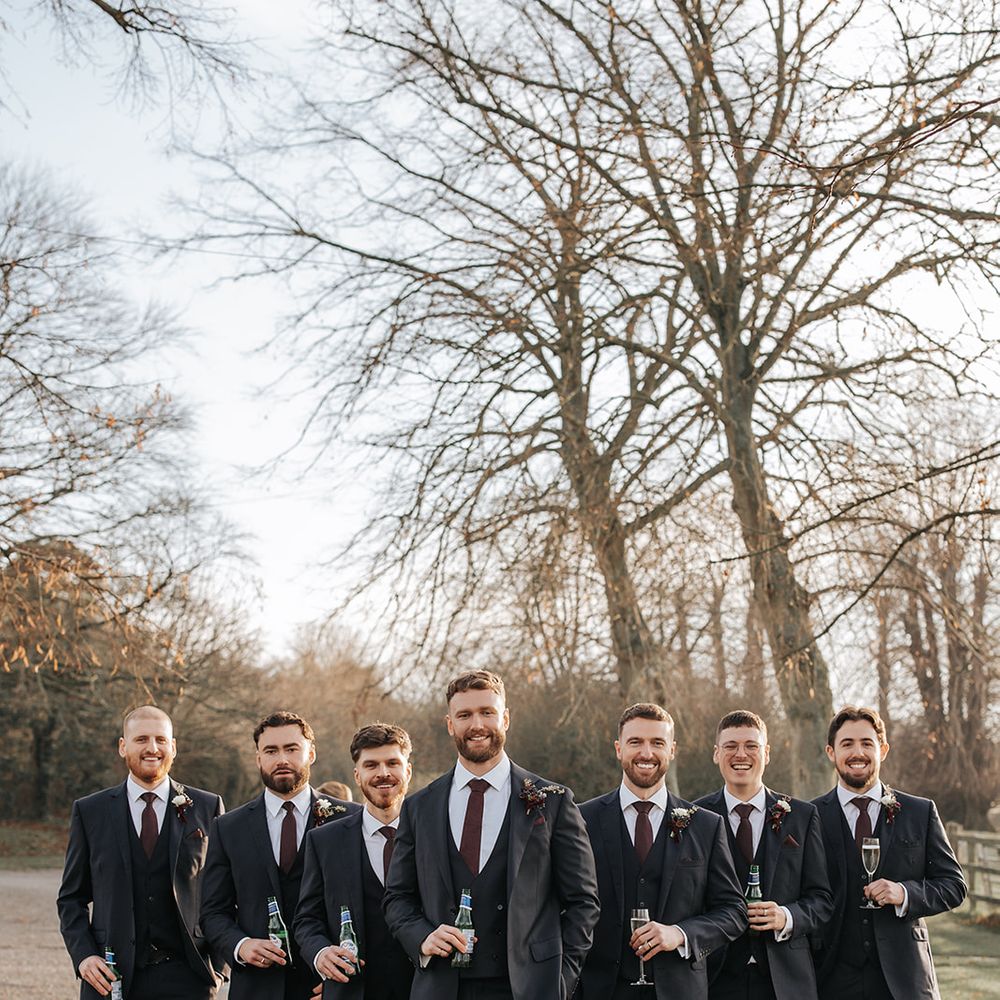 groom and groomsmen in burgundy accessories