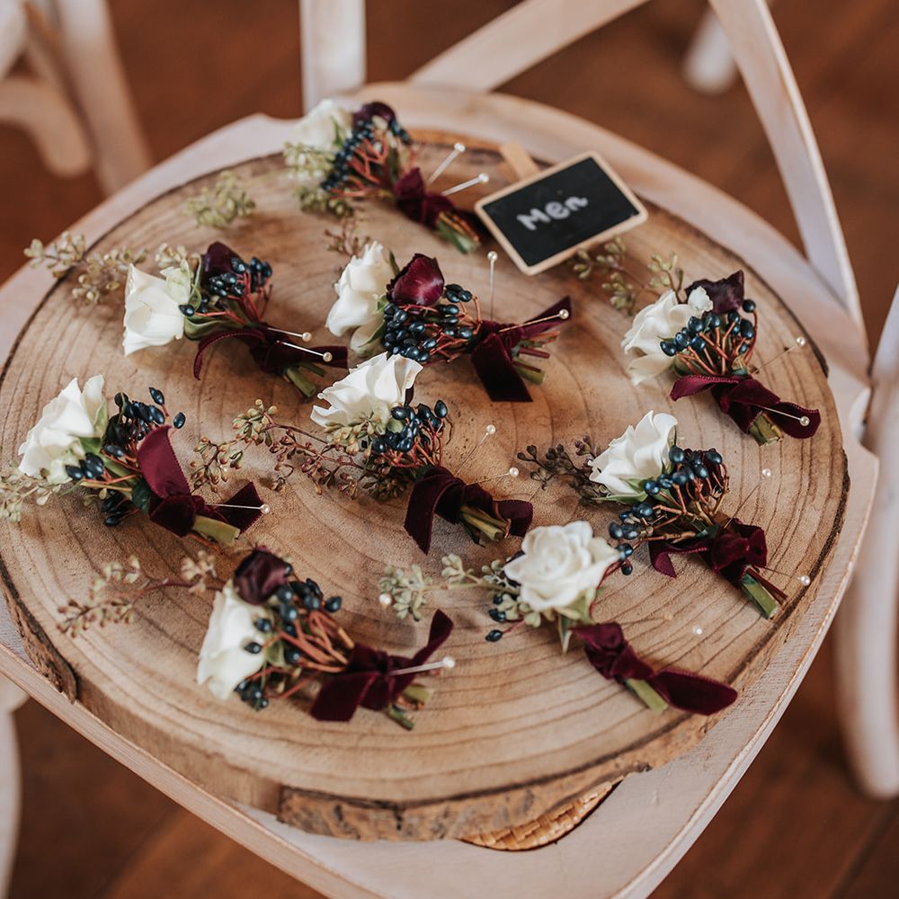 groomsmen white roses burgundy boutonnieres