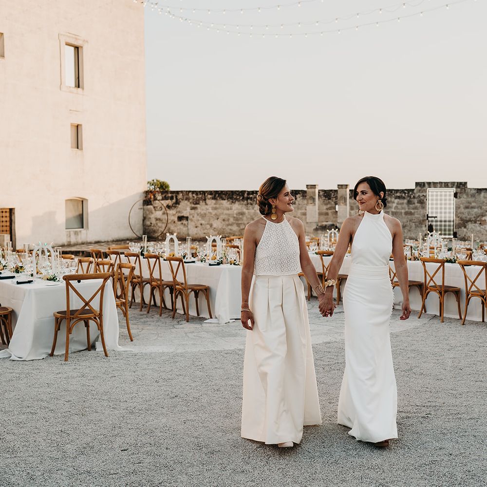 brides holding hands in outdoor reception