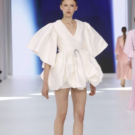 Amarca short wedding dress with wrap bodice and dramatic oversized sleeves at Barcelona Bridal Fashion Week 2026