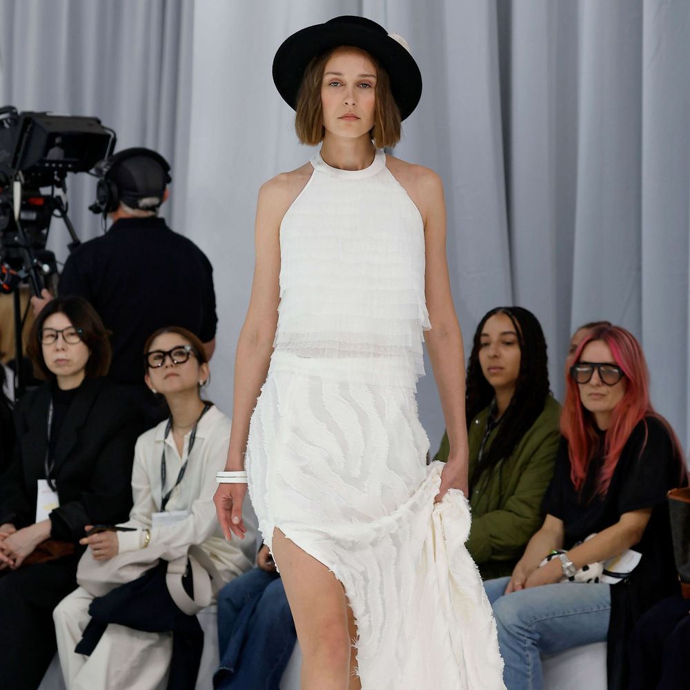 Olga Macia short wedding dress with halter neckline and black hat at Barcelona Bridal Fashion Week 2026