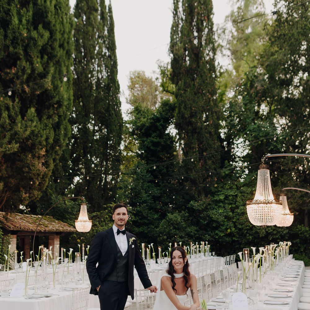 bride groom reception portrait long table chandeliers outdoors