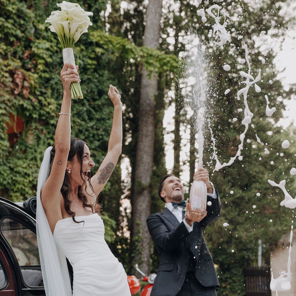 champagne spray celebration bride bouquet groom outdoor party