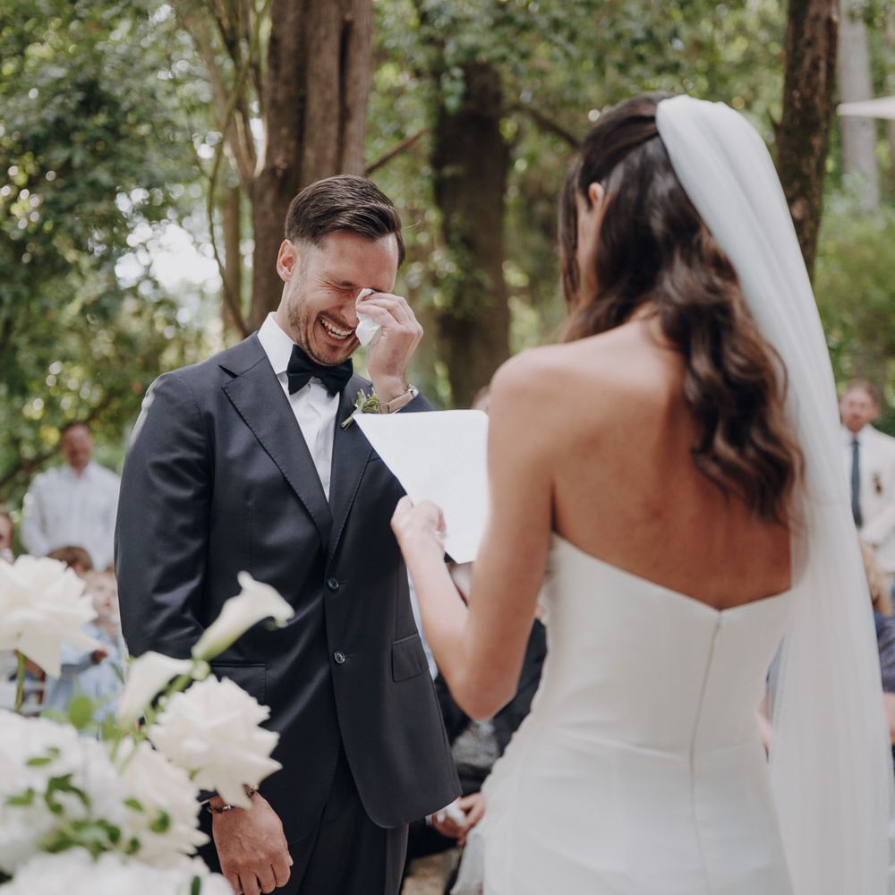 couple vows emotional ceremony white floral backdrop