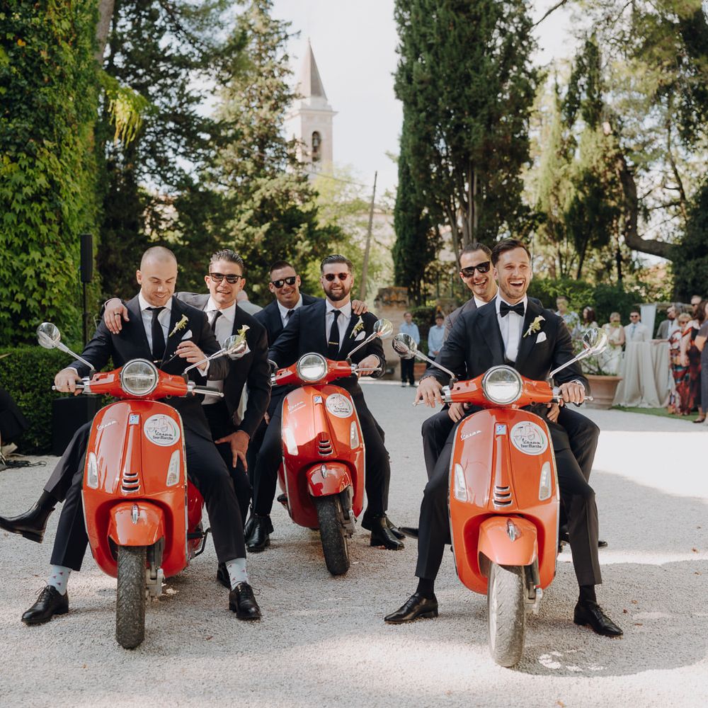 groom groomsmen vespa arrival black tuxedo italian gardens