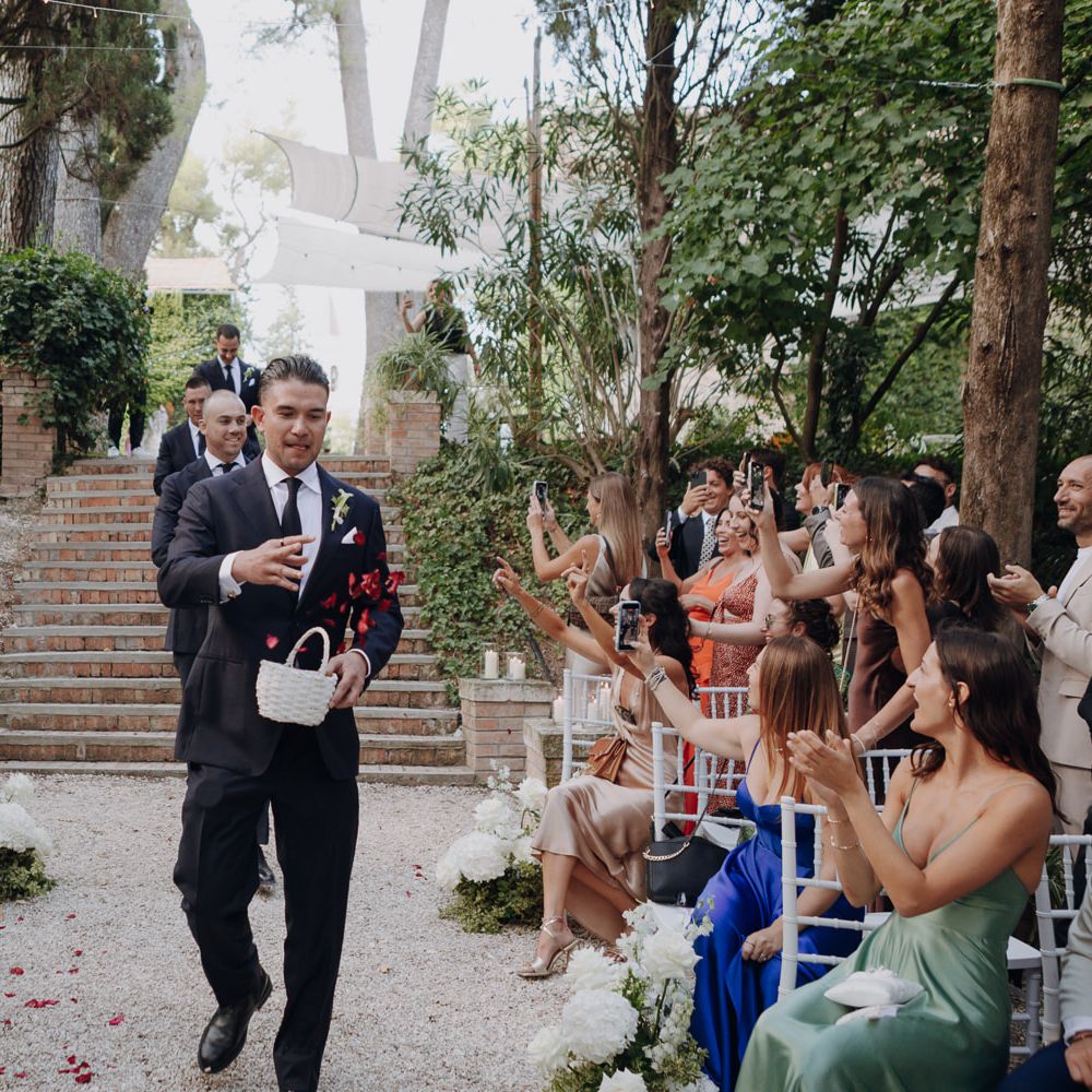 groomsmen aisle rose petal throw outdoor ceremony