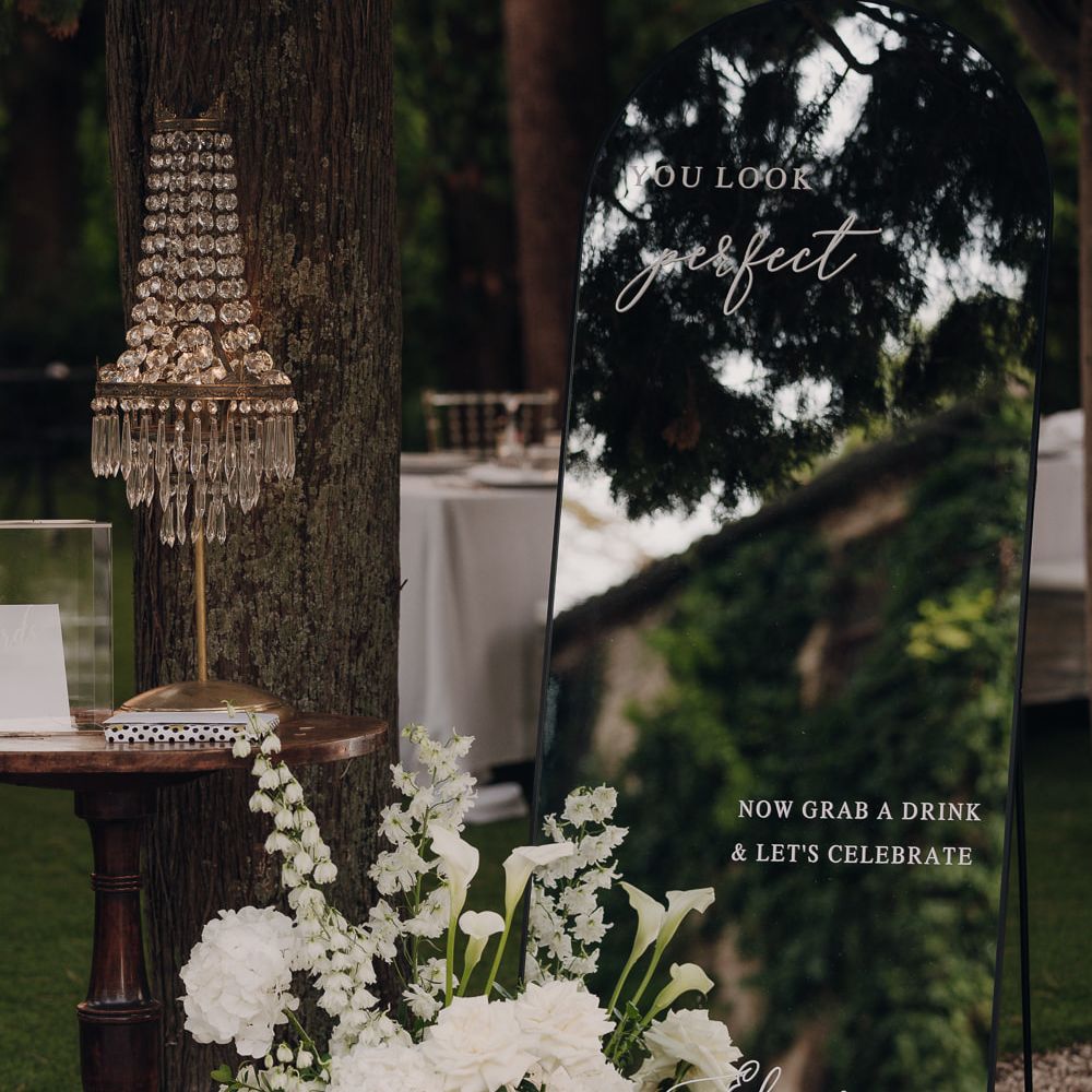 mirrored wedding signage white florals crystal lamp detail