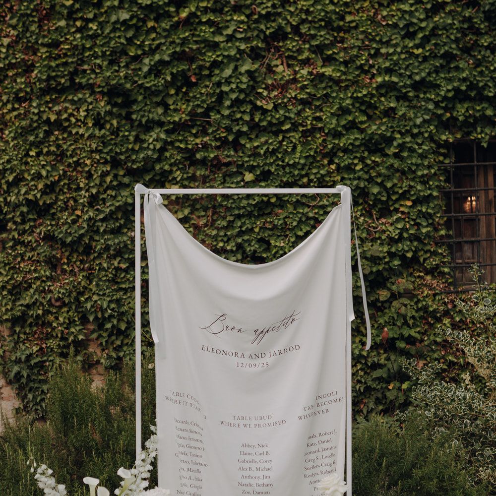 wedding seating plan draped fabric sign white flowers italian garden