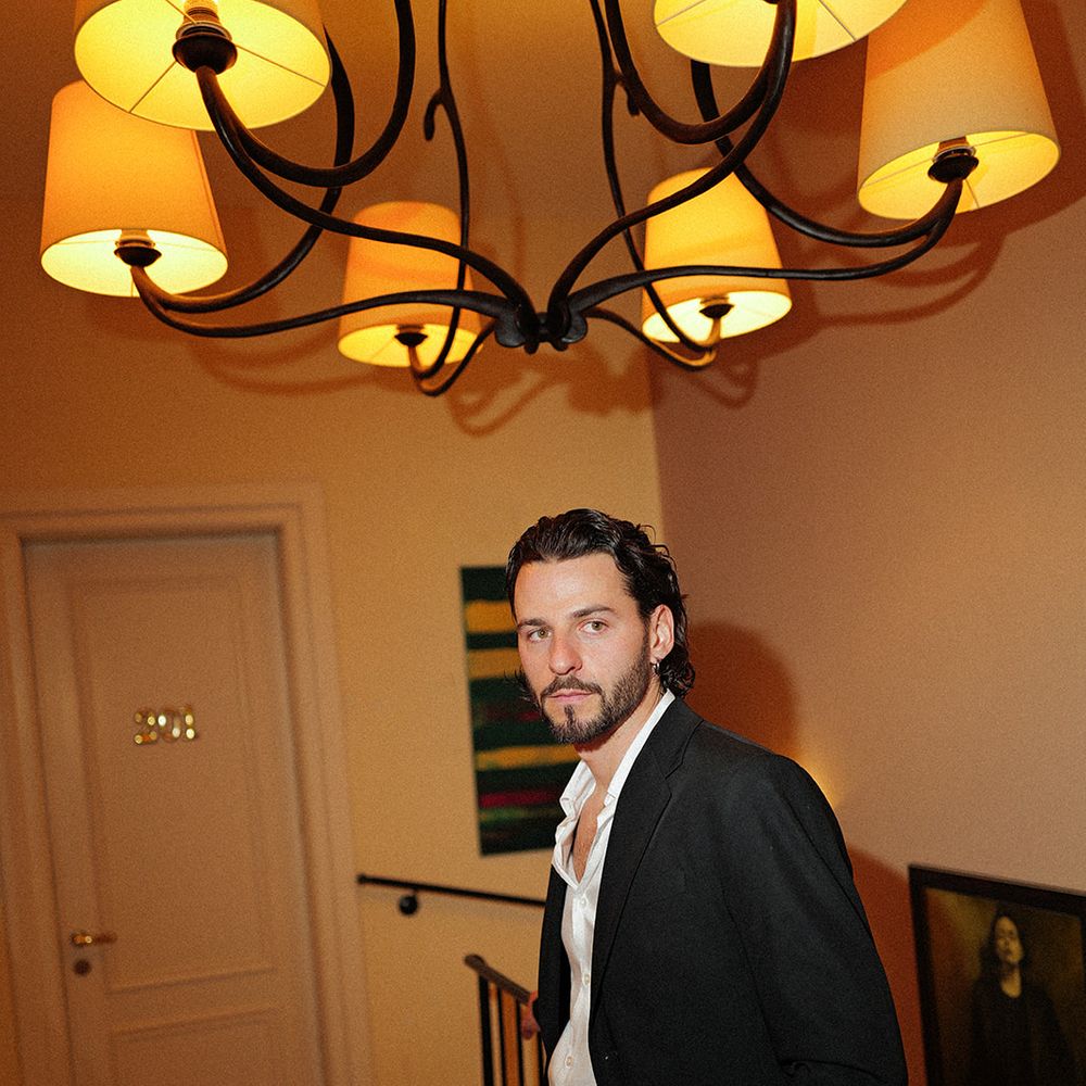 groom portrait warm lighting chandelier wedding editorial