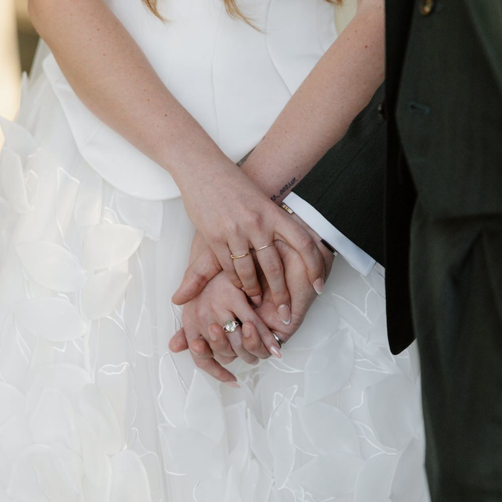 married couple holding hands gold wedding bands