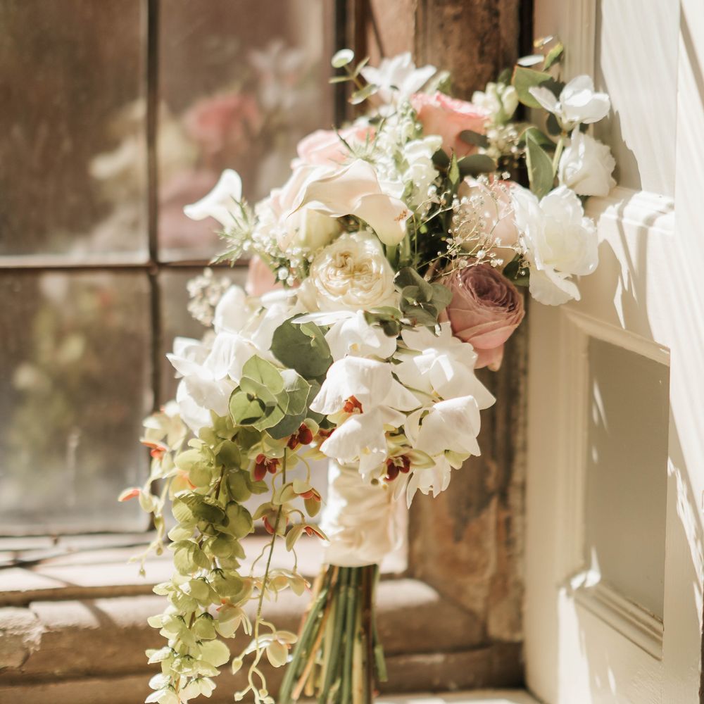 white dusty pink rose lily baby breath bouquet