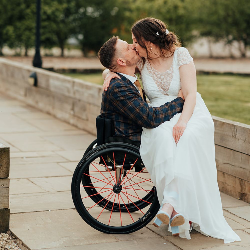 bride groom kiss under light bulb fairy lights