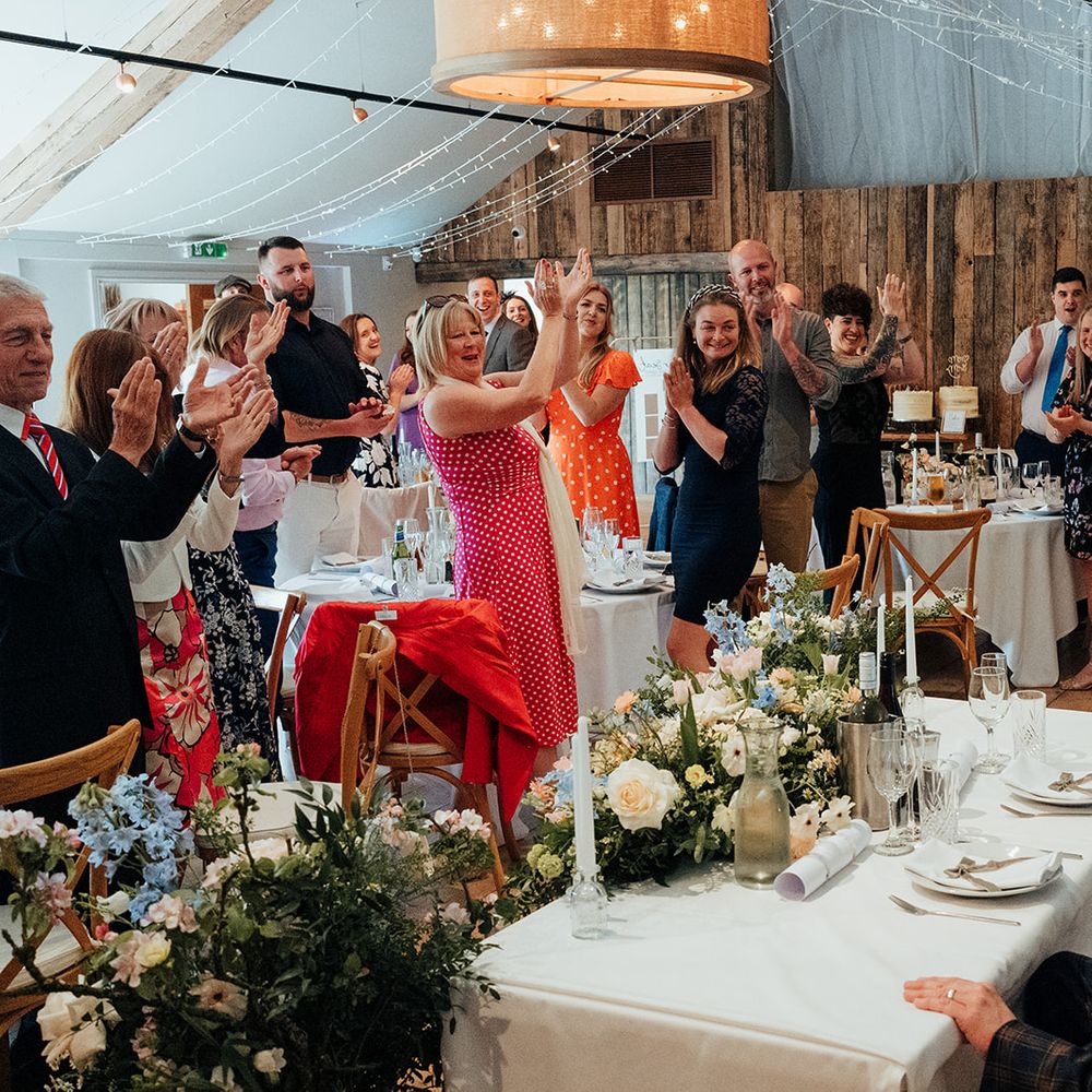 guests cheer married couple wedding breakfast