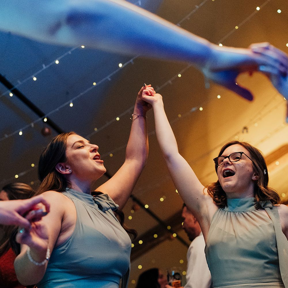guests dancing together under fairylights