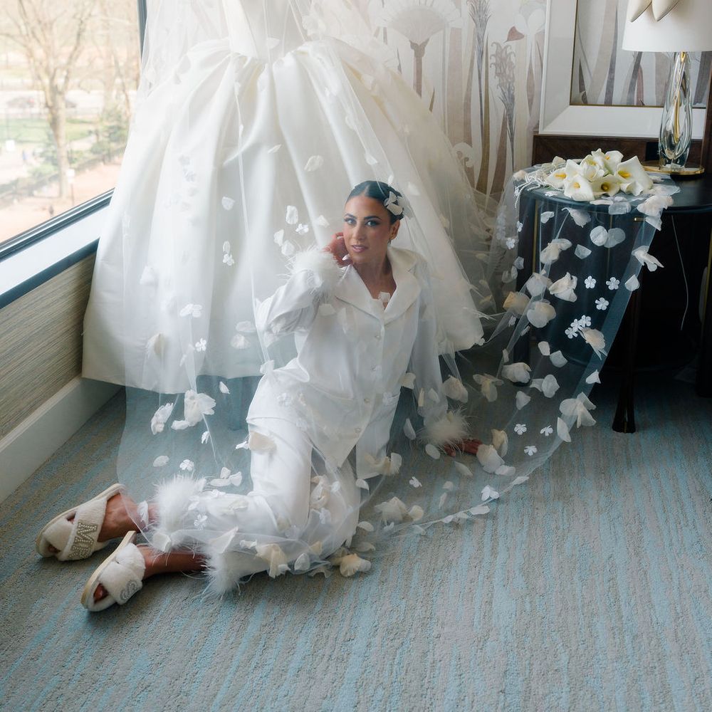 bride getting ready sat with floral veil