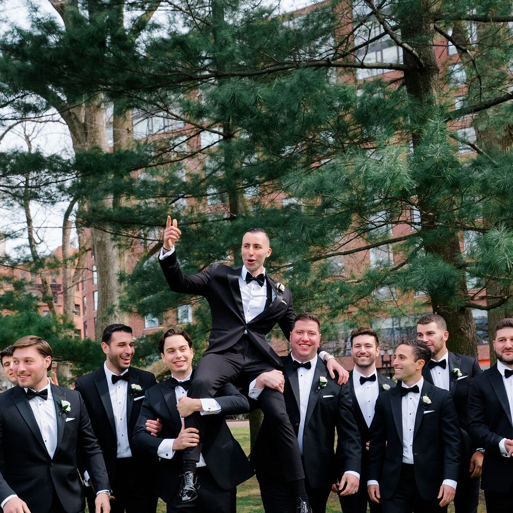groomsmen lifting up groom tuxes