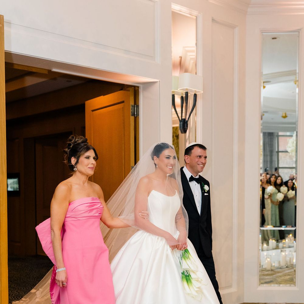mother of bride pink dress walking bride down aisle