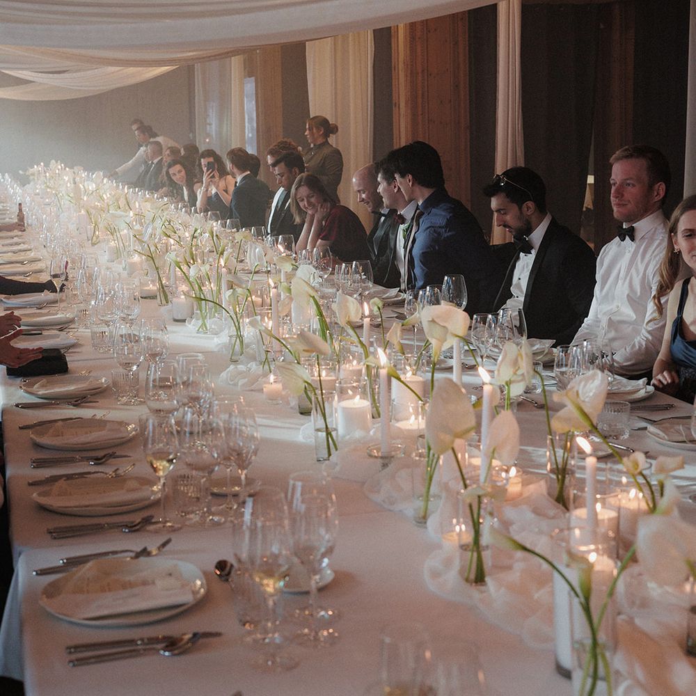 guests seated at candlelit wedding dinner long table