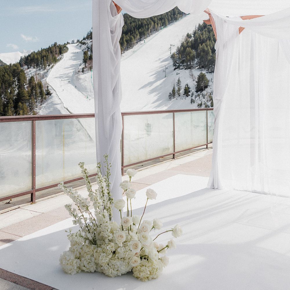 modern white wedding ceremony arch fabric draping snowy ski resort