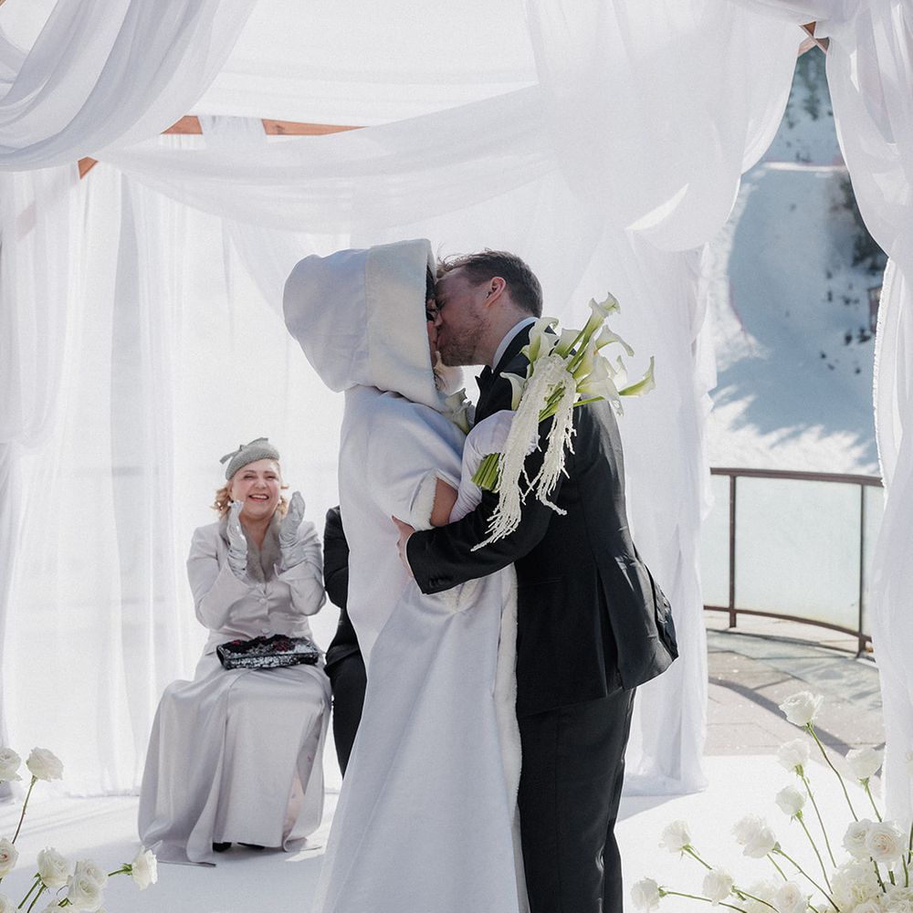 outdoor ski resort wedding first kiss white ceremony arch