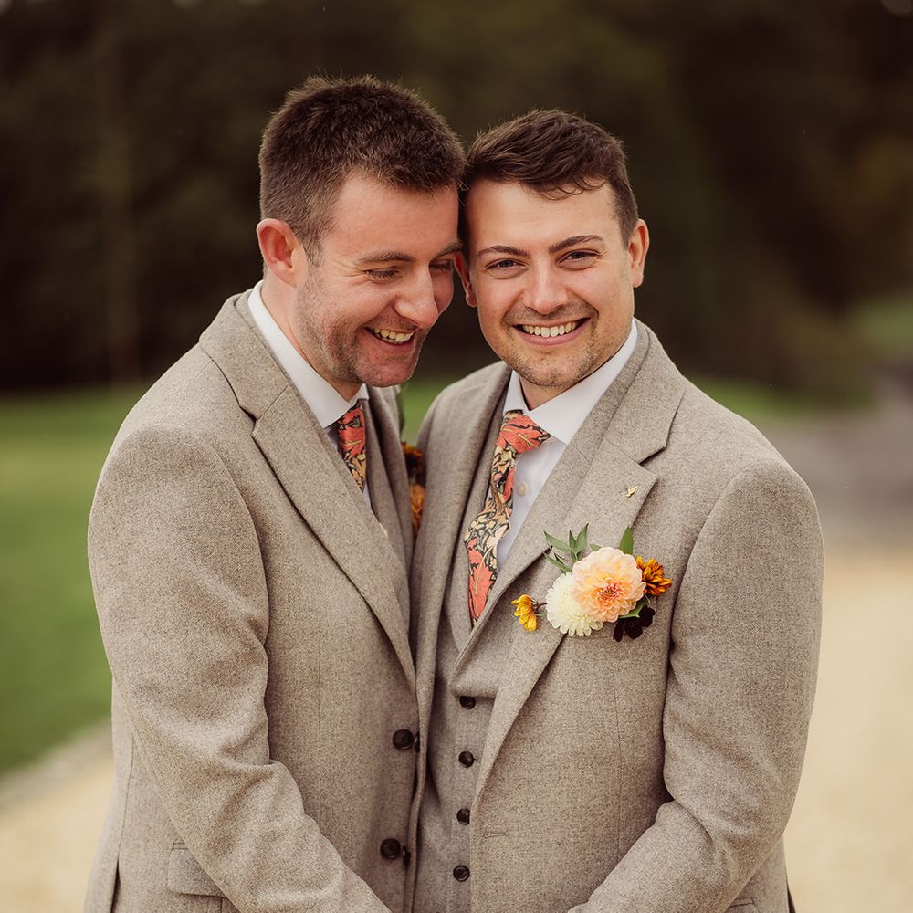 grey three piece suits orange pattern ties orange boutinnieres