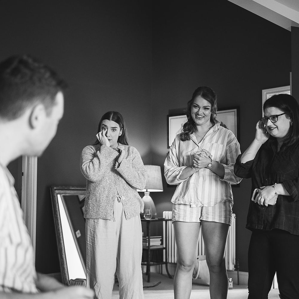 groom getting ready emotional moment bridesmaids