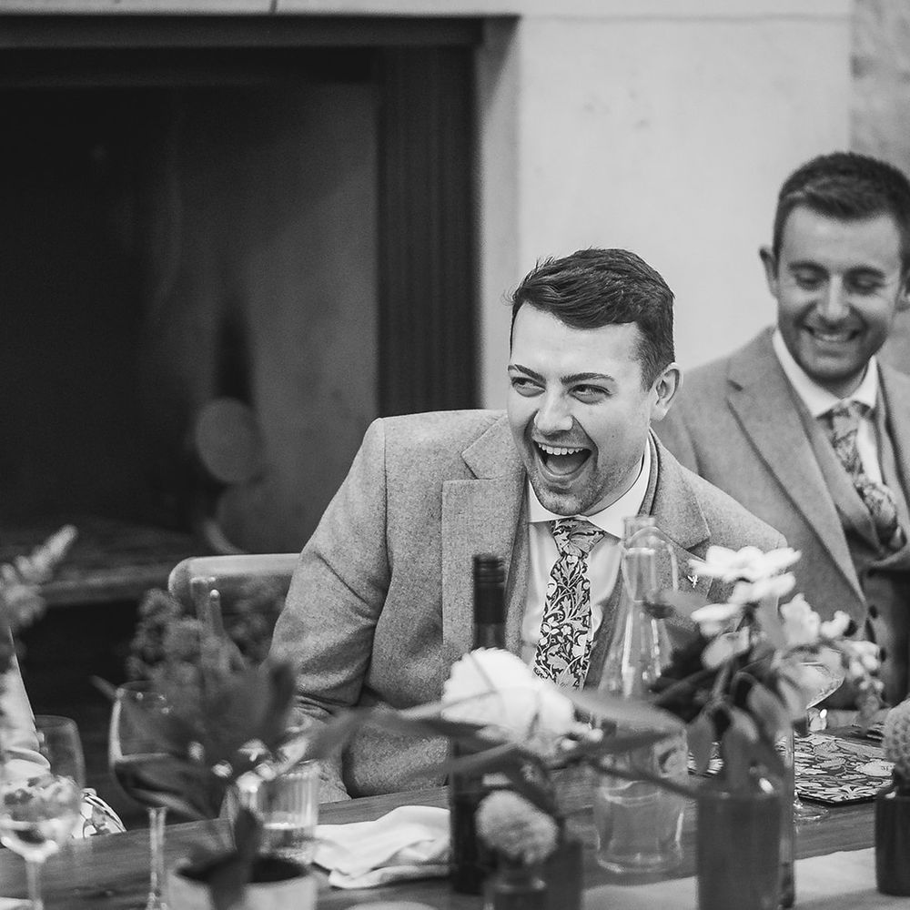 groom laughing with family head of table