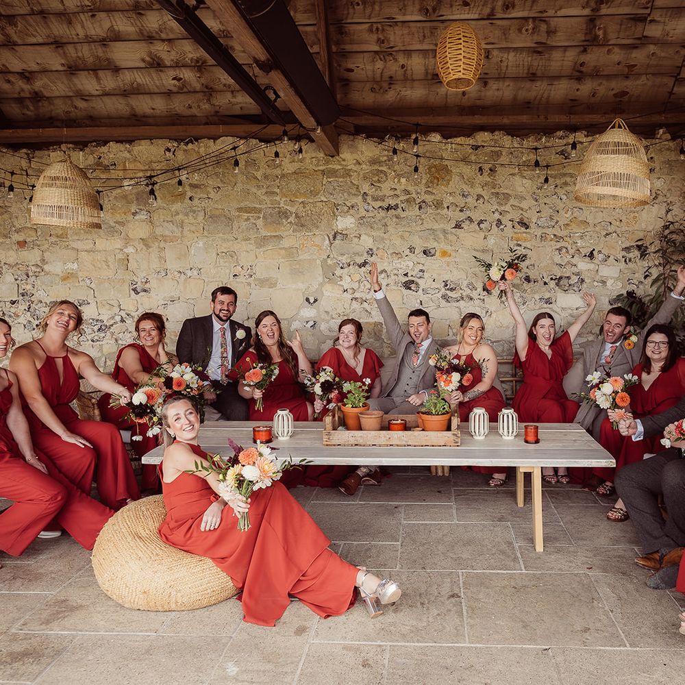 grooms and bridesmaids sat in barn exposed brick decor