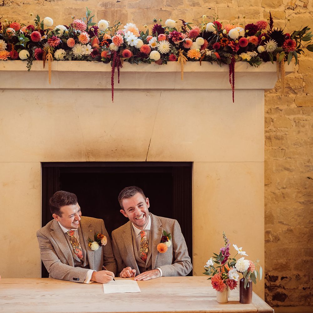 grooms signing wedding papers orange accents decor