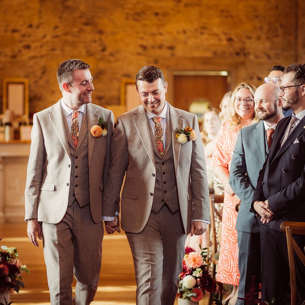 grooms walk down the aisle as married couple