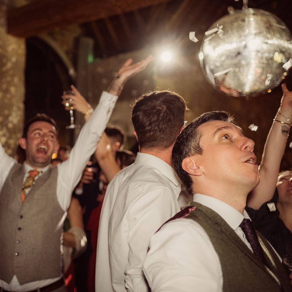 guests and grooms dancing under disco ball