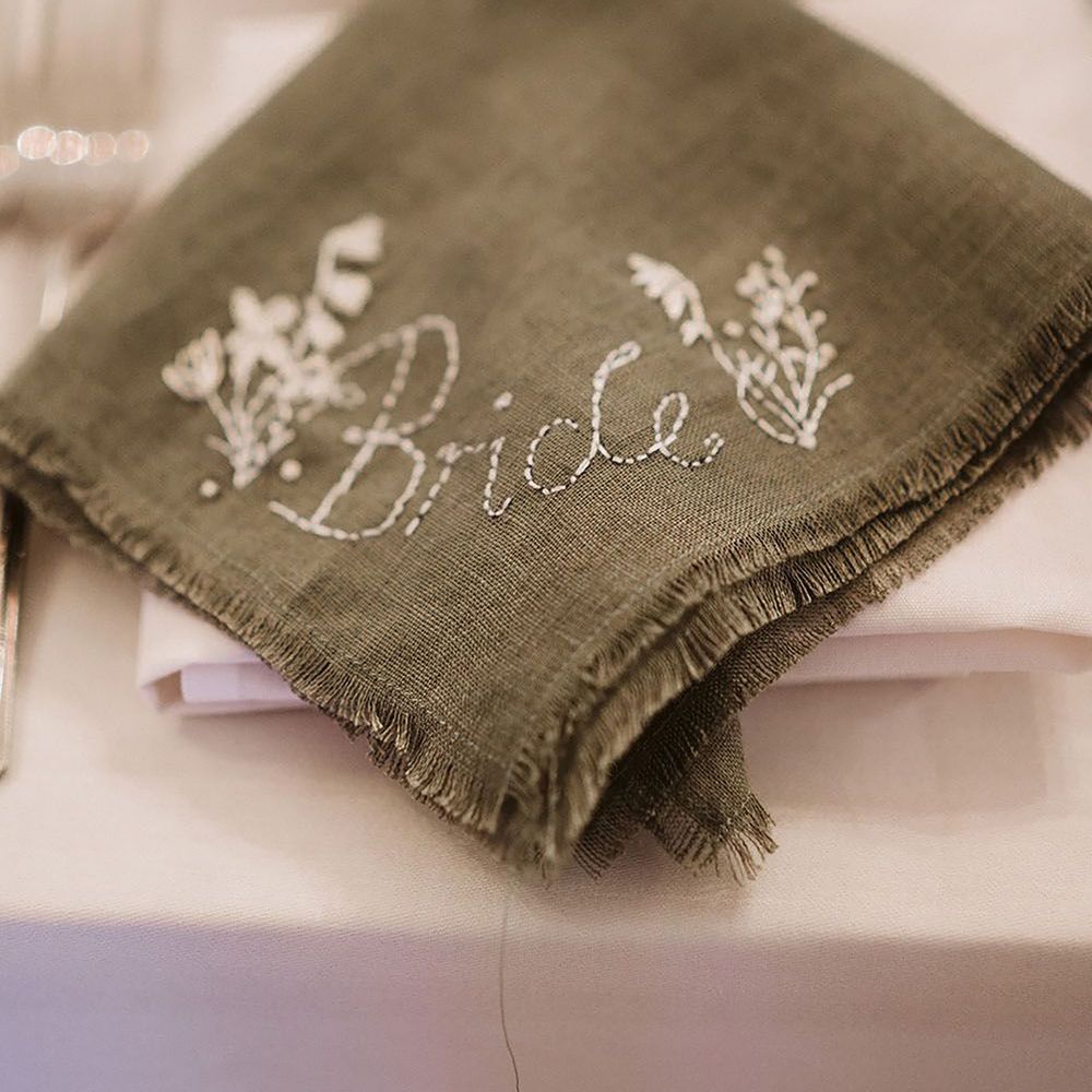 Handmade embroidered green place name napkin finished with floral embroidery