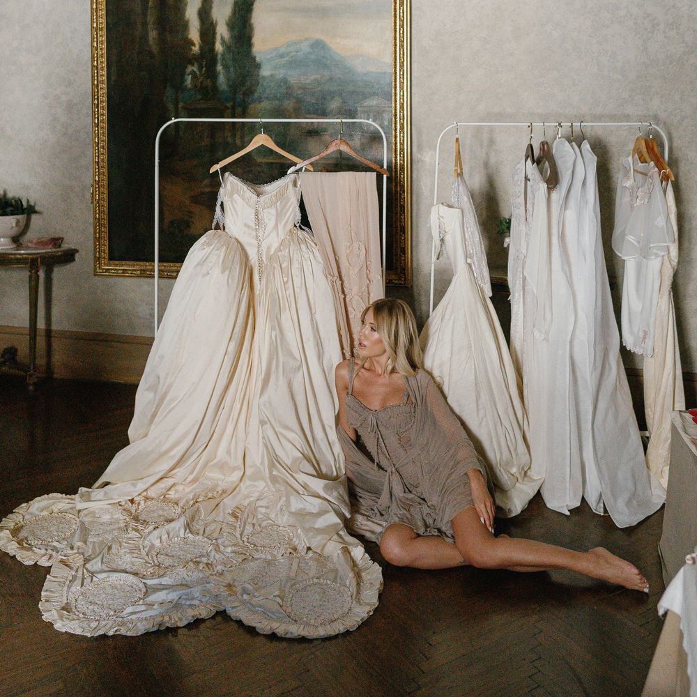 bride getting ready rails of couture wedding gowns
