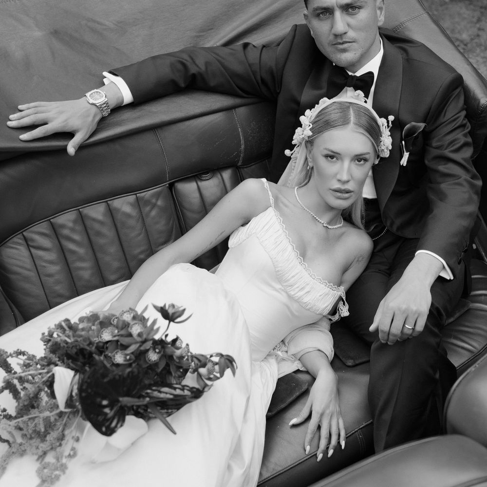 bride and groom in backseat vintage car
