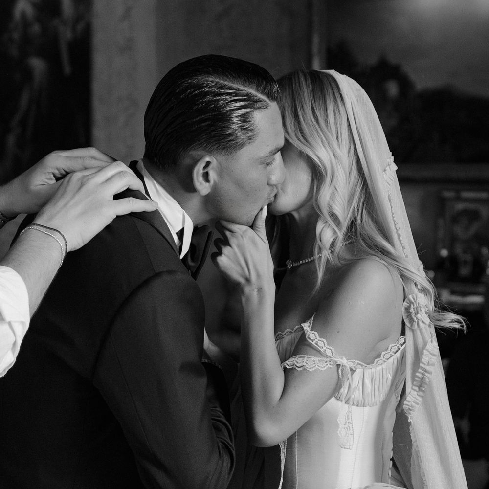 bride and groom kiss whilst getting ready