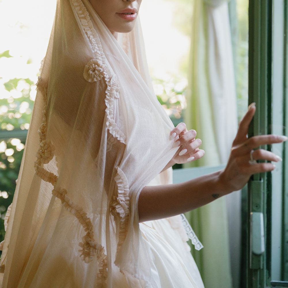 tulle detail floral cream veil bride posing by window