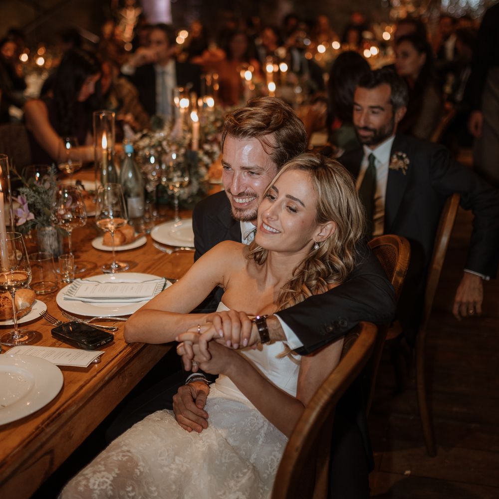 bride and groom embrace at candlelit dinner