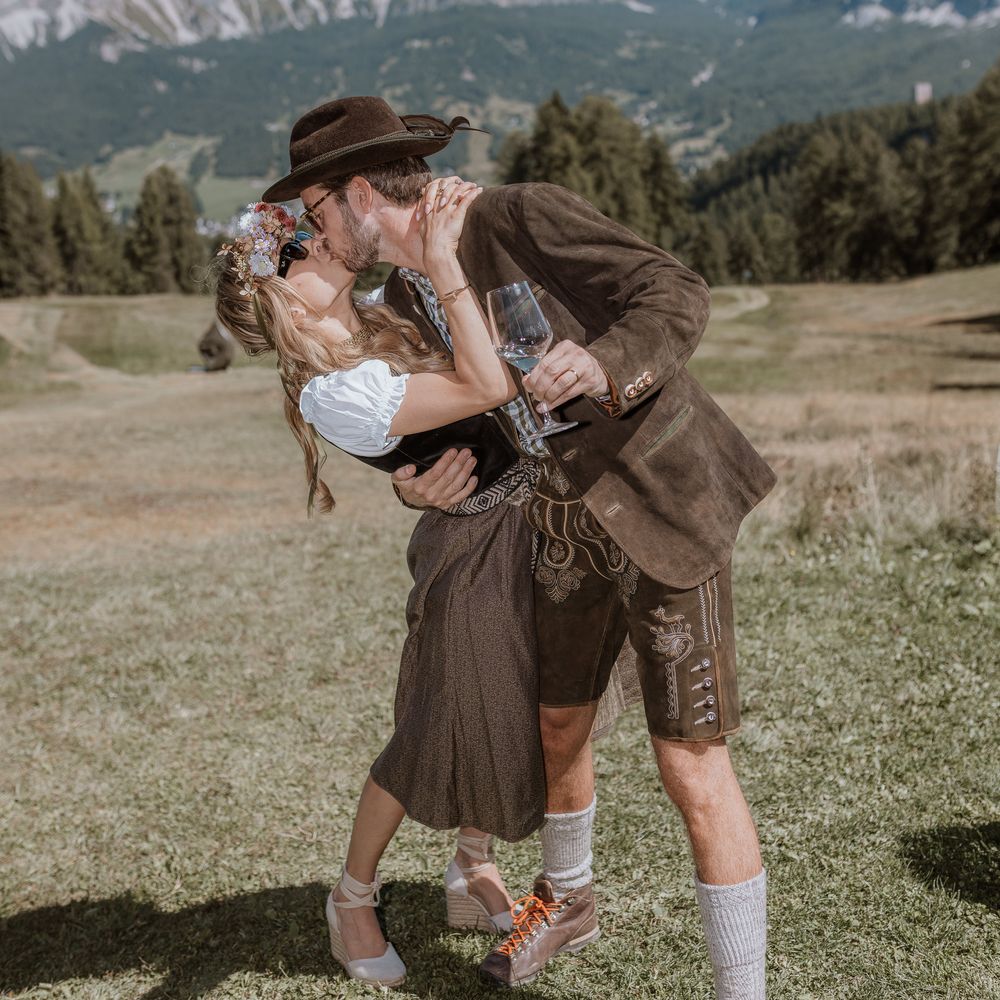 bride and groom kiss in traditional mountain lederhosen