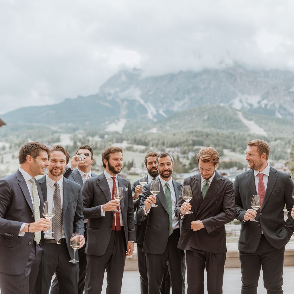 groom and groomsmen getting ready in snowy mountain landscape