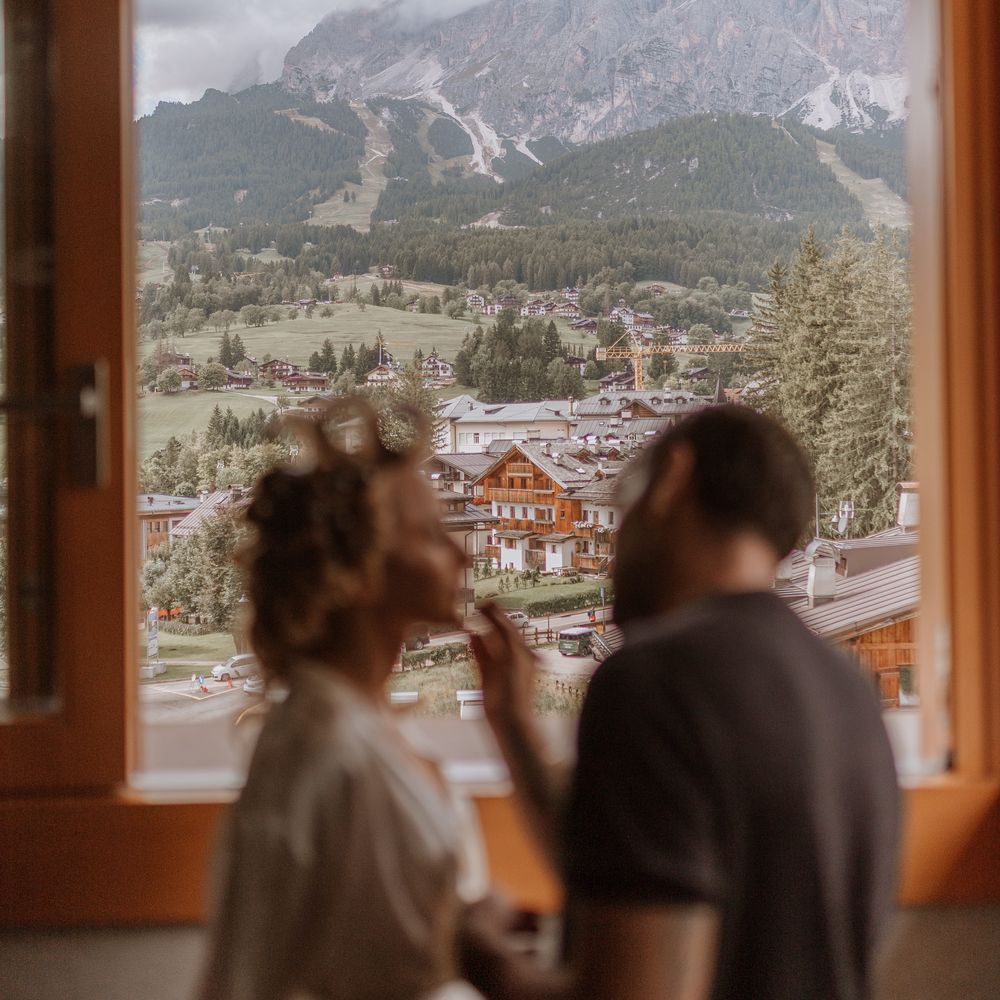 Italian dolomites wedding window view bride getting ready in hair rollers
