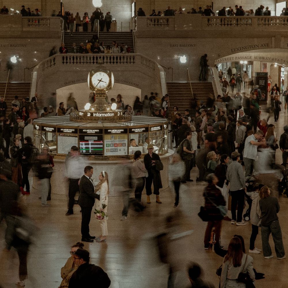 bride and groom embrace in busy grand central station new york