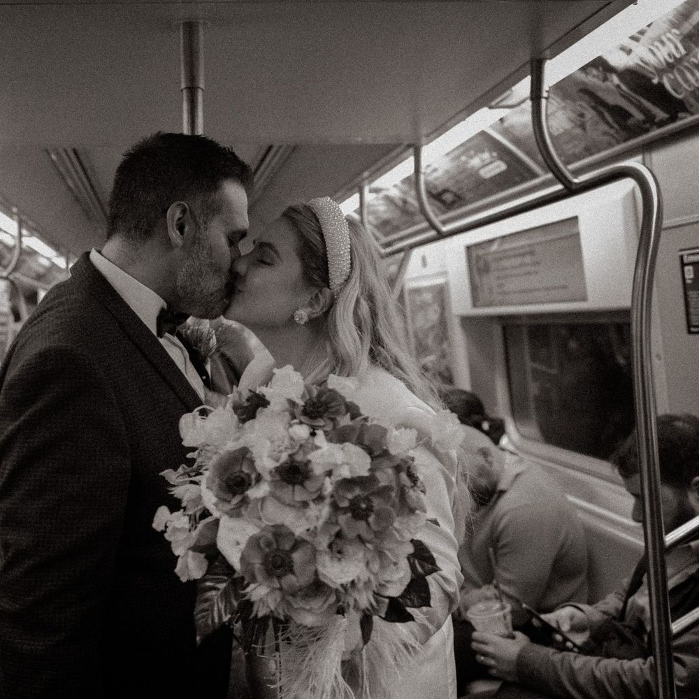 bride and groom kiss in new york subway train
